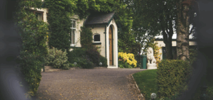older house & driveway with shrubs