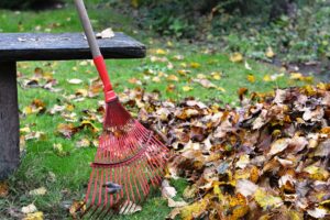red rake leaning against stone bench