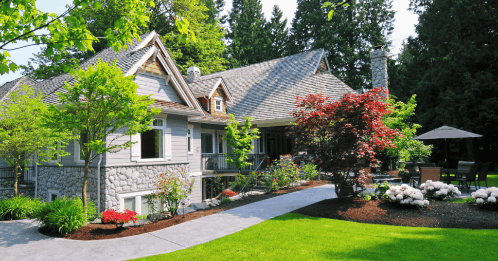 grey home with good summer landscaping