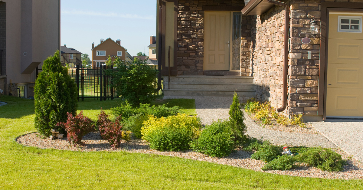 small yard landscaping in the front yard of a stone residential home