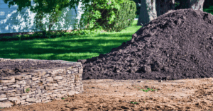 mound of delivered topsoil next to stone wall