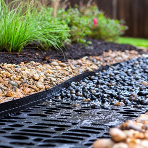 Water flows through a decorative drainage system in a garden